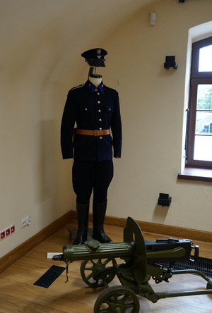 Mundur policjanta oraz armatka na ekspozycji w sali muzeum.