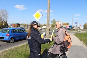 Policjantka wręcza odblask rowerzyście.