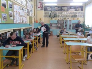 Policjant wręcza uczniom testy.