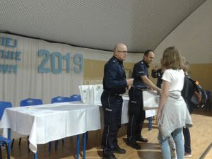 Policjant wręcza nagrody.
