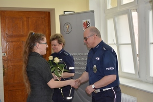 Policjanci otrzymują od uczniów kwiatek w podziękowaniu za ciekawe przeprowadzenie zajęć.