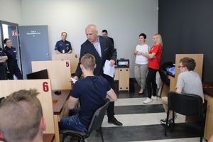 Kierownik rozdaje uczestnikom test.