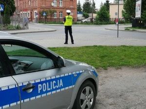 Policjanci działają na drodze i kontrolują uczestników ruchu.