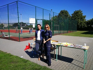 pracownica inspekcji pracy i policjantka przed stoiskiem profilaktycznym