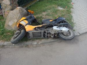 Uszkodzony motorower po kolizji drogowej.
