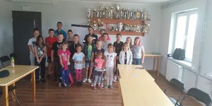 grupa dzieci wraz z policjantką pozuje w dwóch szeregach do wspólnego zdjęcia