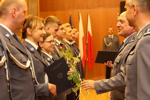 komendanci policji wręczają nominacje na wyższy stopień policjantom. na pierwszym planie komendant powiatowy i policjantka