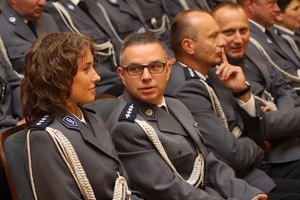 policjanci na widowni szkoły muzycznej. na pierwszym tle aspirant mówiący do policjantki w stopniu nadkomisarza