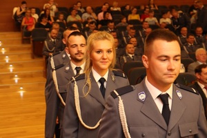 policjanci w szeregu wchodzą na scenę. na pierwszym planie policjantka korpusu szeregowych