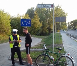 Policjant legitymuje rowerzystę na terenie Inowrocławia.