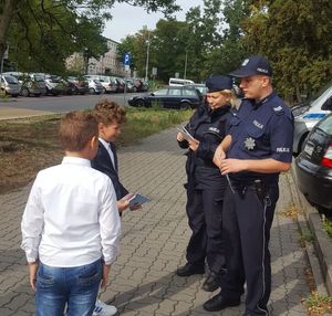 Policjanci rozmawiają z uczniami o drodze do szkoły.