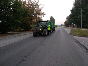 Kierujący ciągnikiem jest badany przez funkcjonariusza WRD.