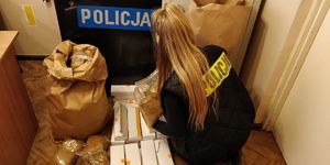 Policjantka przegląda zabezpieczony nielegalny towar w postaci papierosów i tytoniu bez akcyzy.