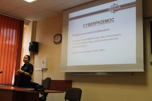 Policjantka omawia prezentacje o cyberprzemocy.