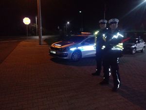 Policjanci stoją na drodze przygotowani do kontroli.