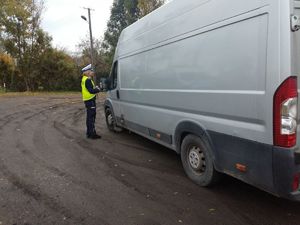 Policjantka sprawdza pojazd typu dostawczego.