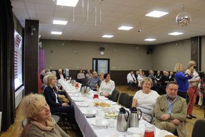 Na zdjęciu widać siedzących seniorów i gości.