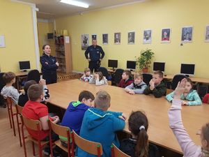 Policjanci mówią uczniom o ruchu drogowym.