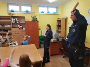 Dzielnicowy uczy dzieci rozróżniania stron, prawej i lewej.