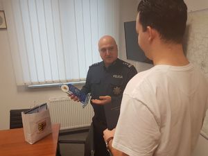Mężczyzna otrzymuje z rąk Komendanta statuetkę