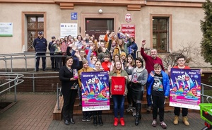 Grupa wolontariuszy w różnym wieku przed Urzędem Gminy Inowrocław. Na pierwszym planie członkowie Sztabu i wolontariusze z materiałami promocyjnymi, plakatami, puszką do kwestowania, materiałowym workiem. W tle umundurowani funkcjonariusze - policjantka i policjant.