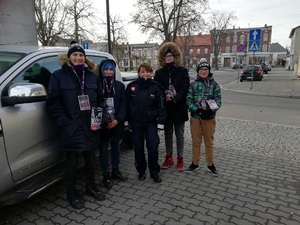 Policjantka stoi wśród wolontariuszy Wielkiej Orkiestry Świątecznej Pomocy