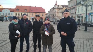 Policjantka i policjant stojący wraz z młodym chłopakiem, wolontariuszem, i jego rodzicami na inowrocławskim rynku