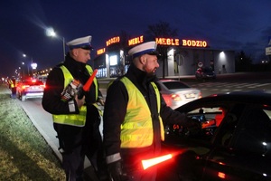 Policjant wręcza broszurkę kierowcy