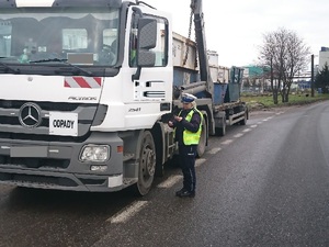 Policjantka kontroluje pojazd ciężarowy