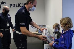 Policjanci przekazują dzieciom upominki