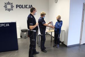 Policjantka wręcza dziecku paczkę