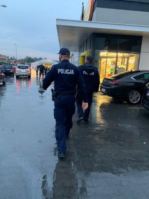 Policjanci idą wzdłuż pasażu handlowego