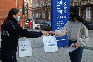 Policjantka wręcza uczennicy paczkę z upominkiem