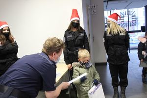 Policjantka zakłada dziecku taśmę odblaskową