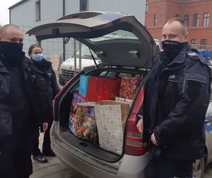 Policjanci pokazują, że paczki wypełniły cały bagażnik pojazdu