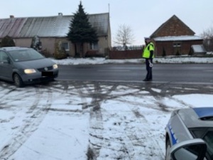 Kierowca pojazdu zatrzymuje się przy policjancie