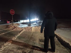 Mężczyzna stoi na ulicy w czarnej odzieży, niewidoczny dla kierowców pojazdów