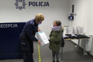 dziewczynka odbiera nagrody od policjantki