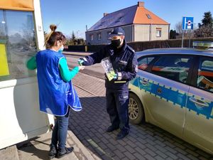 Policjant wręcza odblaski kobiecie
