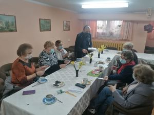 Dzielnicowy w3ęcza ulotki seniorom