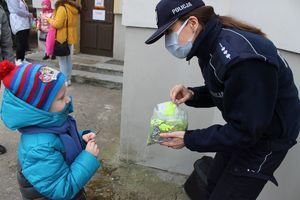Policjantka podaje dziecku odblask