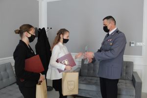 Komendant wręcza dziewczynie upominki