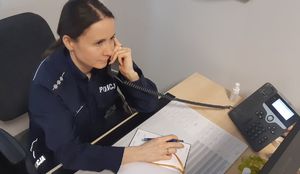 Policjantka odbiera telefon na dyżurze