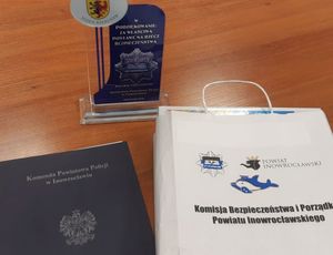 Widok na statuetkę, list gratulacyjny i paczkę upominkową
