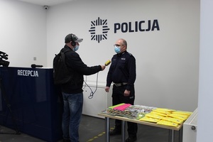 Umundurowany policjant udziela wywiadu dziennikarzowi radia