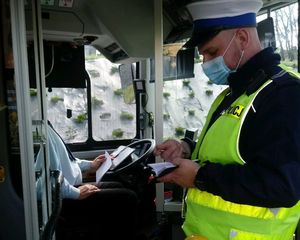 Policjant rozmawia z kierowcą autobusu