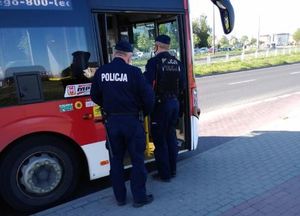 Patrol stoi przy miejskim autobusie