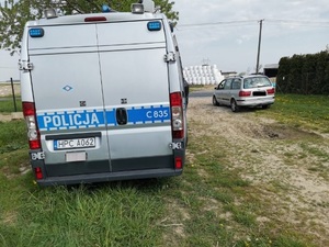Widoczny radiowóz i zatrzymany do kontroli pojazd marki seat