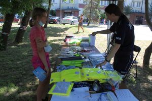 Dziecko odbiera kamizelkę od policjantki