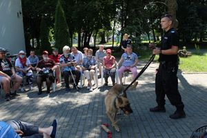 Policjant z psem bawiącym się gryzakiem